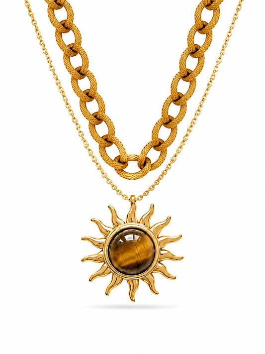 Dual-layer gold necklace set with textured curb chain and delicate cable chain featuring tiger's eye cabochon sunburst pendant — white background